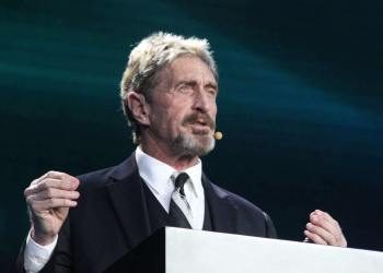 John McAfee on a podium