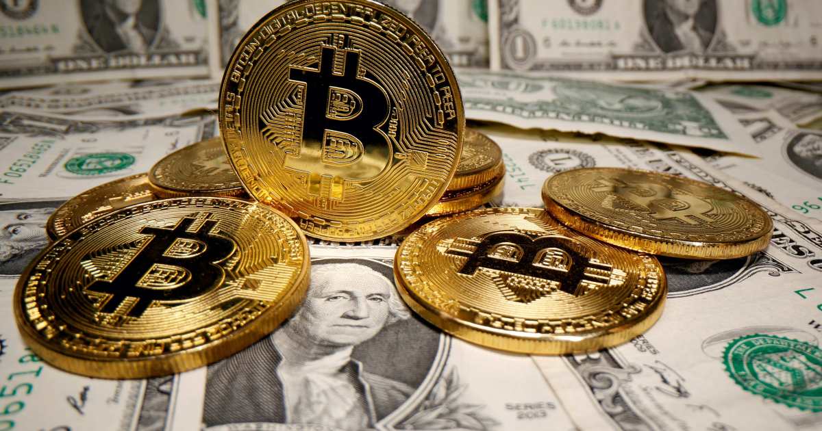 Picture of four bitcoin on a floor covered with U.S. dollar currencies