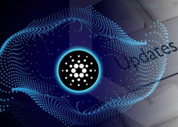 Picture of a Cardano symbol with updates written a computer keyboard key behind it