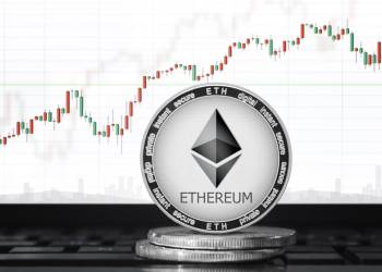 Picture of an ethereum coin standing on two other coins with a candlestick price chart behind it