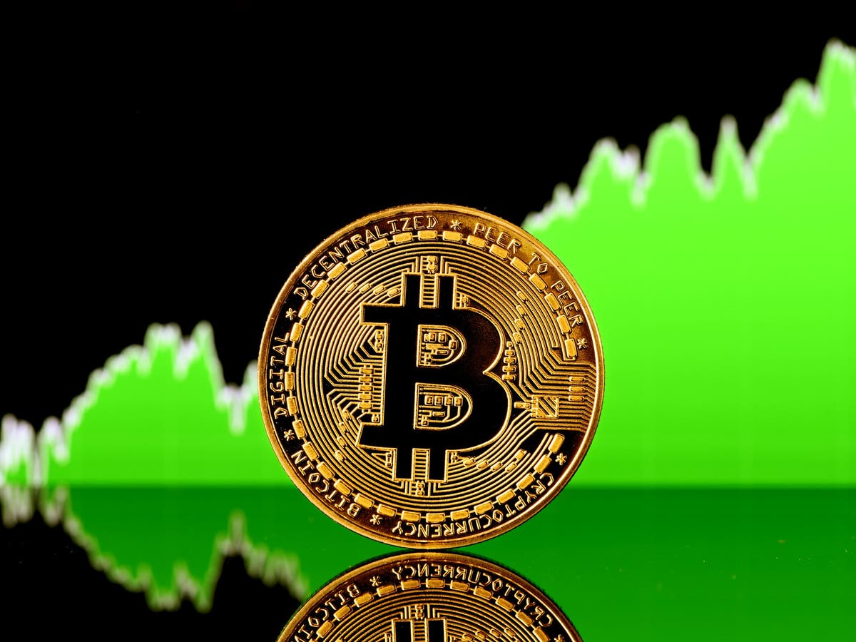 Picture of a bitcoin with a green upward chart behind it
