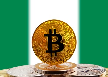 Bitcoin standing on top of other bitcoins with a Nigerian flag in the background