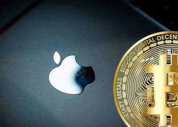 Picture of a gold bitcoin next to an Apple device, depicting Coinbase adding Apple Pay
