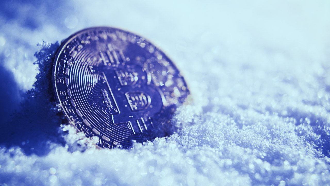 Picture of a bitcoin with snow surrounding it