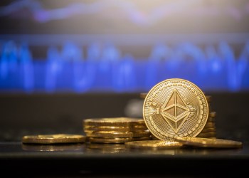 Picture of an ETH coin standing with other Ethereum coins laying around it
