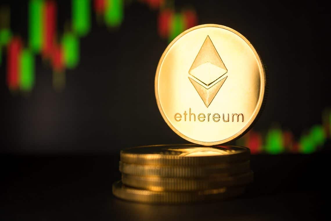 Picture of an Ethereum coin standing on top five stacked Etheruem coins, with a candlestick chart behind it