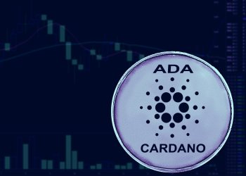 Picture of a Cardano coin in front of a candlestick chart