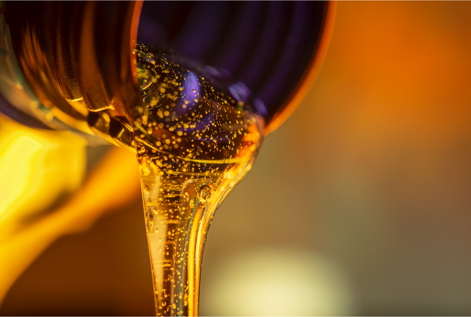Picture of a gold liquid being poured out of a bottle, representing liquidations