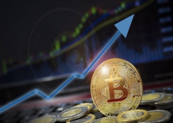 Picture of a gold bitcoin with a blue arrow pointing upwards behind it