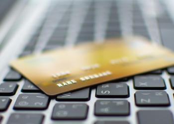 Picture of a gold debit card on a computer keyboard, depicting COTI debit cards