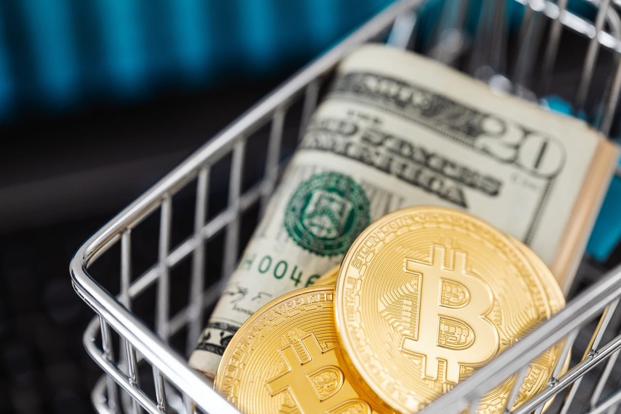 Picture of two bitcoins in a cart with a folded $20 bill