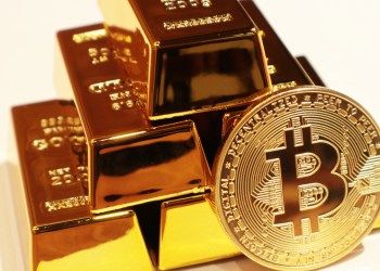 Bitcoin in front of gold bars