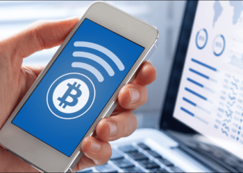 Picture of a hand holding a mobile phone with a bitcoin logo on it