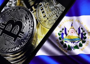 Picture of a bitcoin on top an El Salvador flag