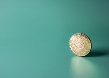 Ethereum cryptocurrency coin on green background with copy space