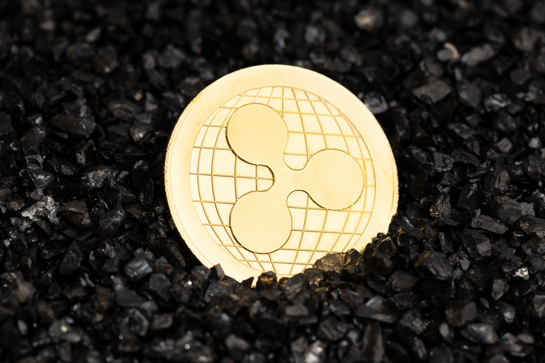 Ripple XRP coin on black gravel background