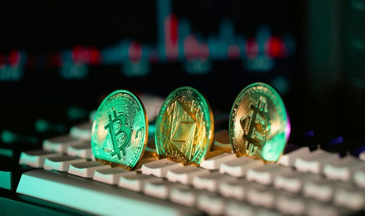 パソコンキーボード上に並んだ3つの仮想通貨コイン